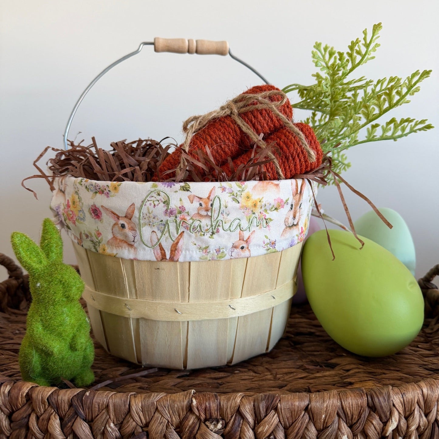 Decorative Easter basket with eggs and a bunny on a woven tray.